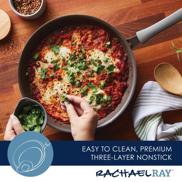 A person skillfully garnishes a dish with herbs in a high-performance Cook + Create Nonstick Frying Pan made of thicker gauge aluminum.