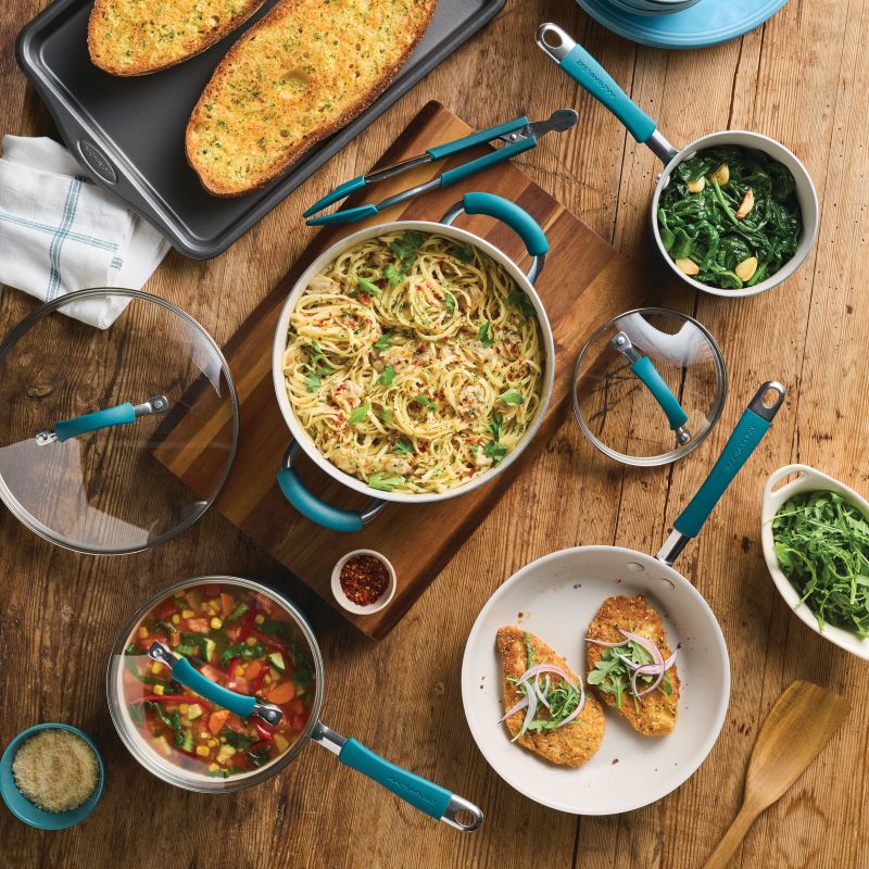 Table set with pasta, salad, greens, and stew in 8-Piece Ceramic Nonstick Cookware Set.