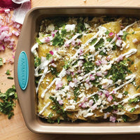 A baking dish of enchiladas topped with cheese, onions, and cilantro becomes even more delightful when prepared in the 2-Piece 9-Inch Nonstick Square Cake Pans.