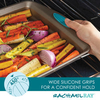 A baking sheet with vibrant vegetables and blue silicone grips sits in the oven, highlighting the nonstick properties of the Nonstick Baking Sheet and Bench Scrape Set.