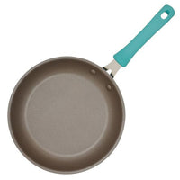 The Cook + Create Nonstick Frying Pan showcases superior performance with its thicker gauge aluminum design and an eye-catching blue handle, captured from an overhead perspective.