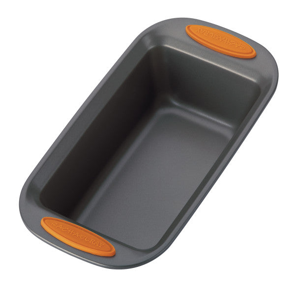 Gray loaf pan crafted from durable heavy gauge steel and equipped with orange silicone grips on both ends. With an oven-safe rating of up to 500°F, this loaf pan is an essential component of the 5-Piece Nonstick Bakeware Set.