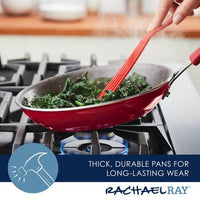 A red pan from the Cook + Create Nonstick Cookware Sets on a gas stove exemplifies nonstick cookware at its best, with greens being expertly sautéed using a red utensil.