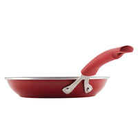 The Cook + Create Nonstick Frying Pan features a vibrant red finish, an ergonomic handle, and is crafted from thicker gauge aluminum for enhanced durability.