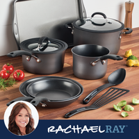 Cookware set on a kitchen counter with utensils and fresh vegetables.