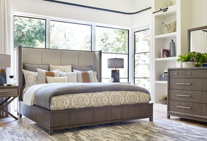 Modern bedroom with gray furniture and large windows.