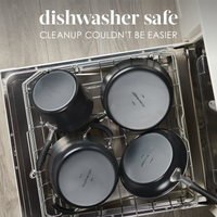 Four black pots placed in a dishwasher for cleaning.