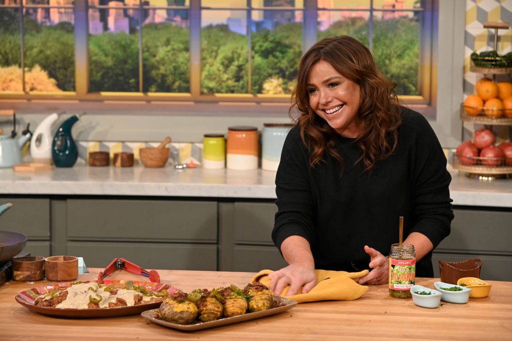 Person preparing food in a kitchen with dishes on the counter.