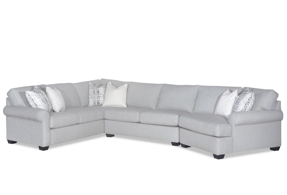 Gray sectional sofa with patterned and solid white pillows.
