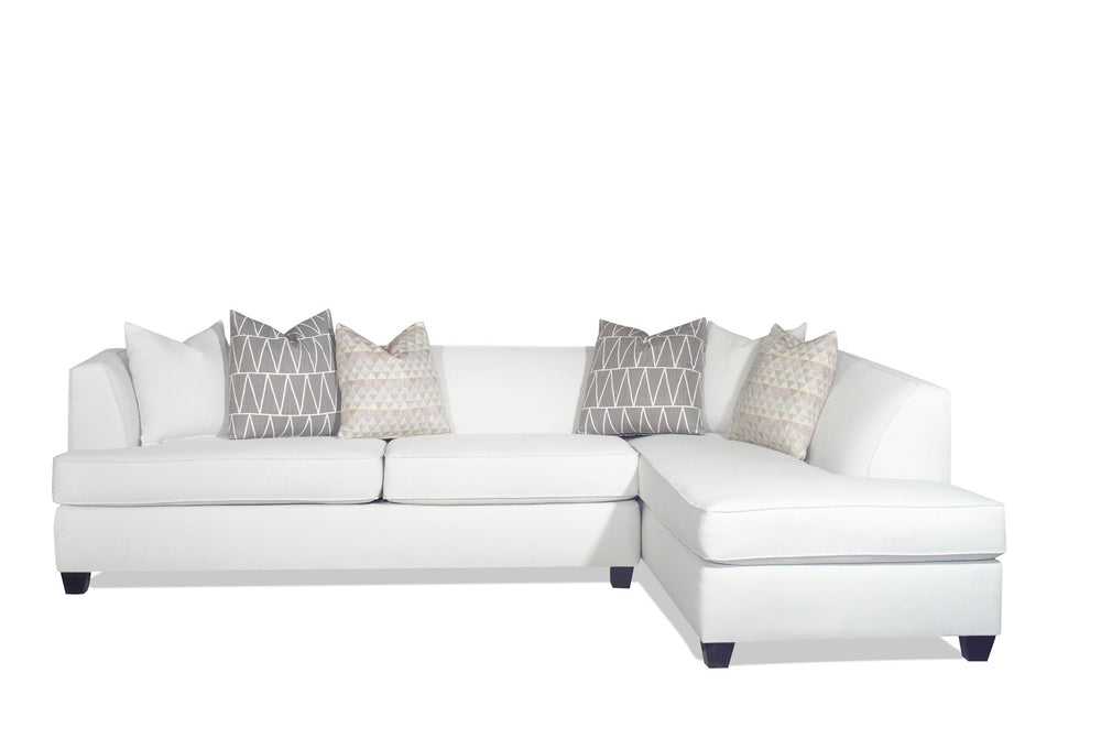 White L-shaped sofa with four patterned gray pillows.