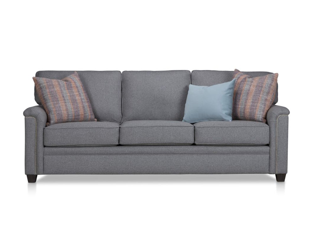Gray sofa with three cushions and three decorative pillows.