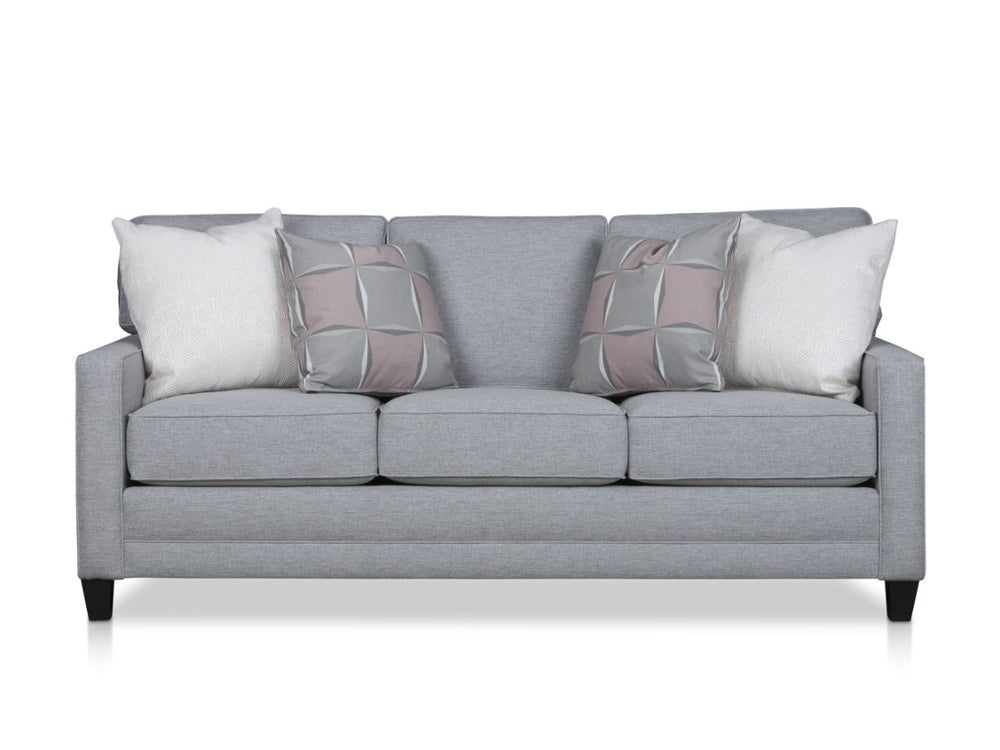 Gray sofa with patterned and plain pillows arranged neatly on it.