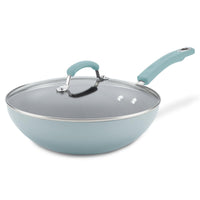 Light blue non-stick frying pan with a glass lid and ergonomic handle.