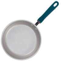 A white frying pan with a dark handle, viewed from above.