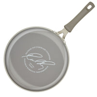 The 3-Quart Cook + Create Nonstick Sauté Pan with Lid, featuring a gray nonstick surface and a signature on the bottom, is designed to be oven safe for versatile cooking.