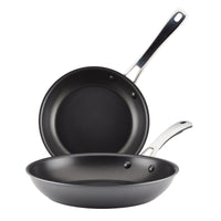 The 2-Piece Cook + Create Hard Anodized Nonstick Frying Pan Set includes two black frying pans crafted from hard-anodized aluminum, featuring metal handles and designed to nest together for convenience.