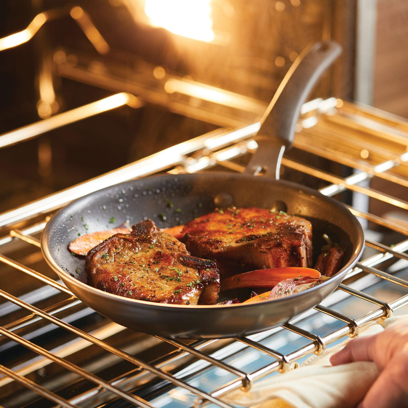 Steak sizzles to perfection in the oven using the 10-Piece Cook + Create Hard Anodized Nonstick Cookware Set, showcasing the brilliance of hard-anodized aluminum cookware.