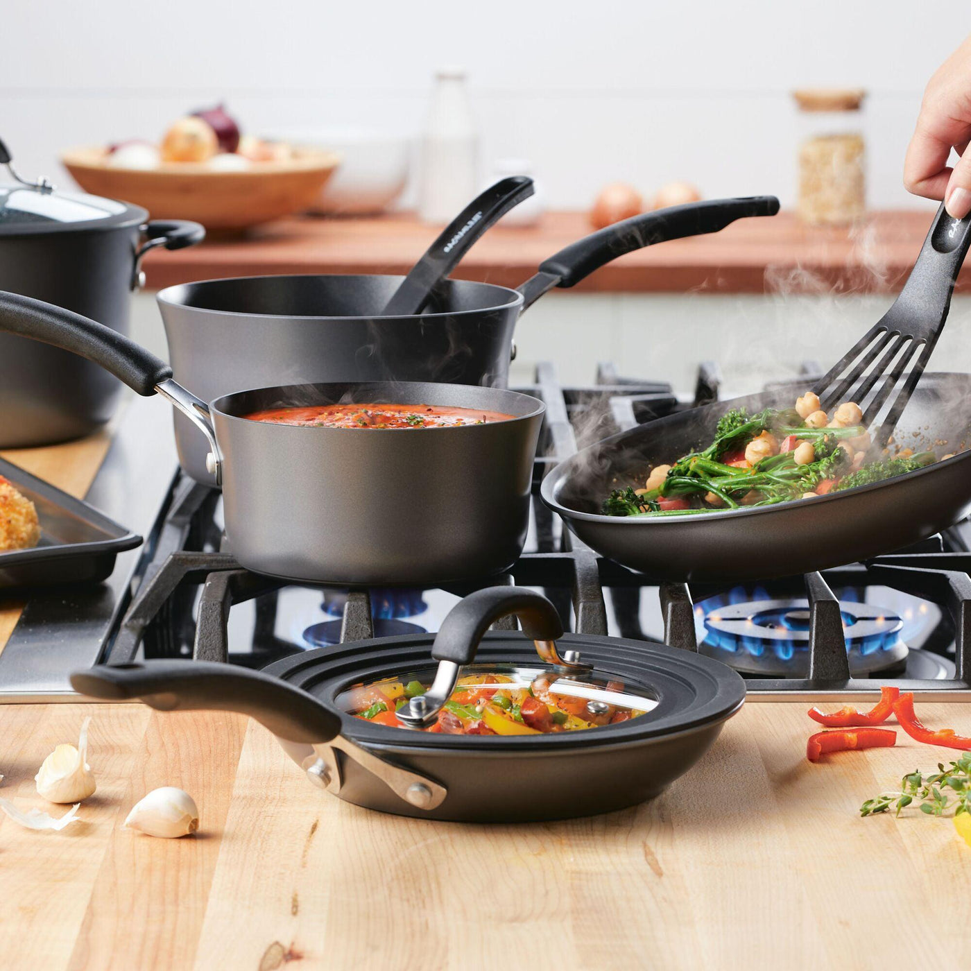 The 10-Piece Cook + Create Hard Anodized Nonstick Cookware Set gracefully dances on the stovetop, showcasing the elegance of its hard-anodized aluminum design.