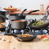 The 10-Piece Cook + Create Hard Anodized Nonstick Cookware Set gracefully dances on the stovetop, showcasing the elegance of its hard-anodized aluminum design.