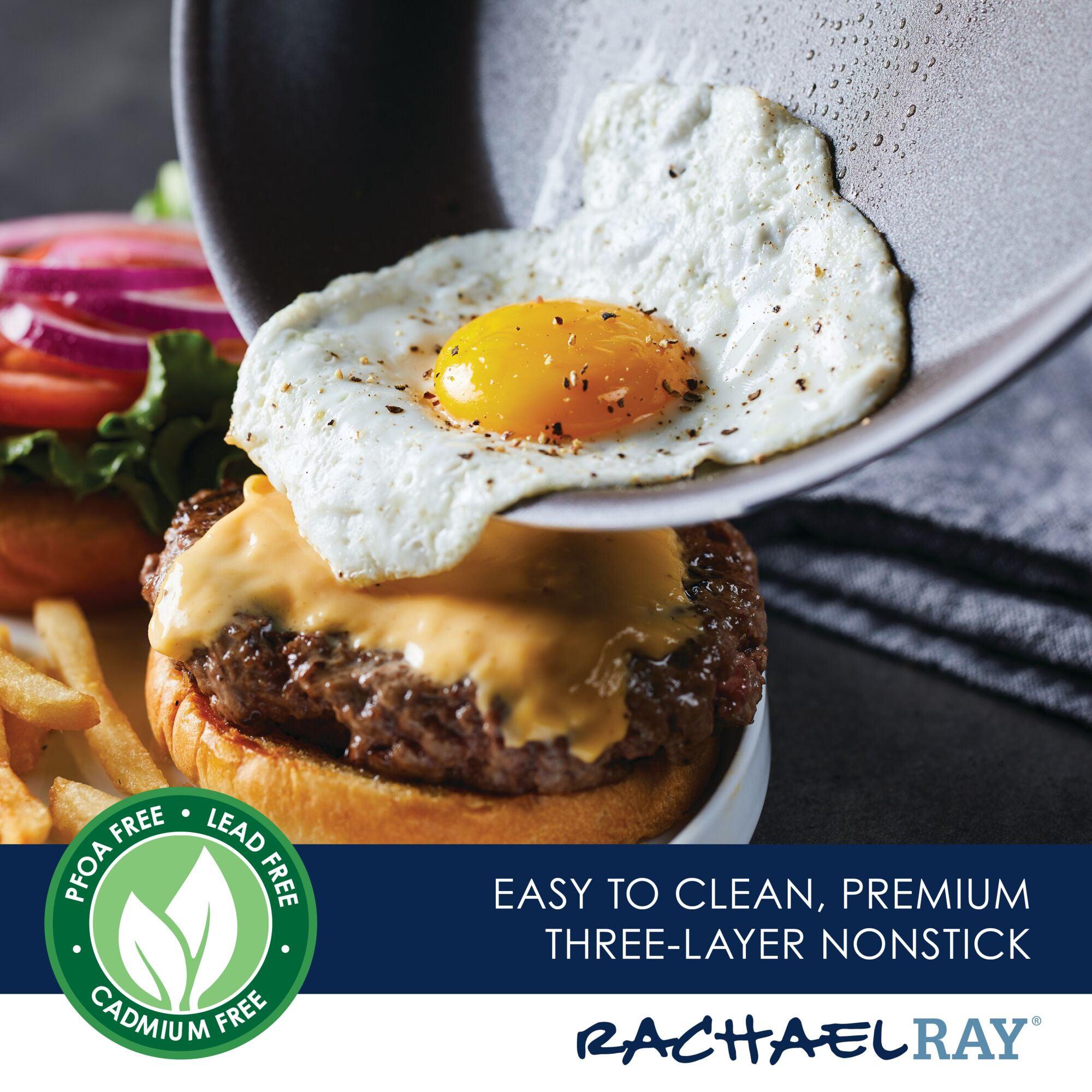 A fried egg, perfectly cooked in a 2-Piece Cook + Create Hard Anodized Nonstick Frying Pan Set, is being placed on a cheeseburger with lettuce, tomato, and onion.