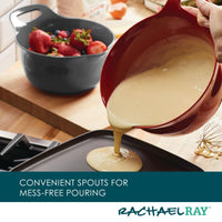 A stylish mixing bowl from the 2-Qt. & 3-Qt. Nesting Mixing Bowl Set, featuring a non-slip rubberized bottom, allows for easy batter pouring through its convenient spout onto the cooking surface.