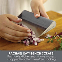 Hands using the Bench Scrape - Rach's Food Mover to swiftly transfer chopped onions, acting as an efficient tool on the cutting board.