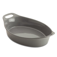 The Ceramic Oval Bakers, featuring a convenient handle, sits empty against a pristine white background. Designed for versatility, it transitions effortlessly from freezer to oven, making your culinary creations both stylish and effortless.