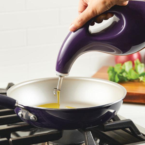 Transfer oil from the 24-Ounce EVOO Bottle into a frying pan on the stove using precision pouring, assisted by a stainless steel pour spout.