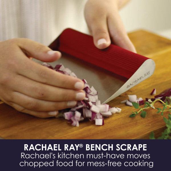 A person uses the Bench Scrape - Rach's Food Mover to efficiently gather chopped onions from the cutting board.