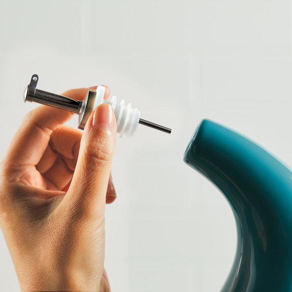 A hand inserting a stainless steel pour spout into the 24-Ounce EVOO Bottle, ensuring precision pouring with every use.